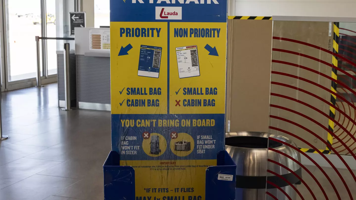 A Ryanair cabin baggage measurement cage at an empty boarding gate in an airport.