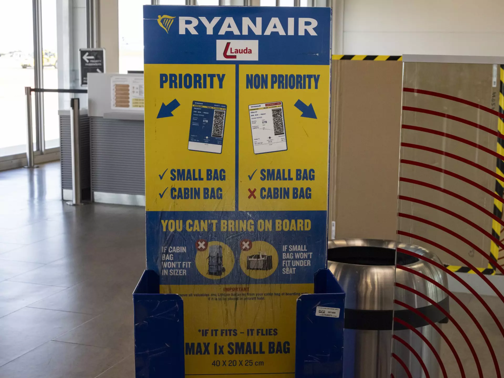 A Ryanair cabin baggage measurement cage at an empty boarding gate in an airport.