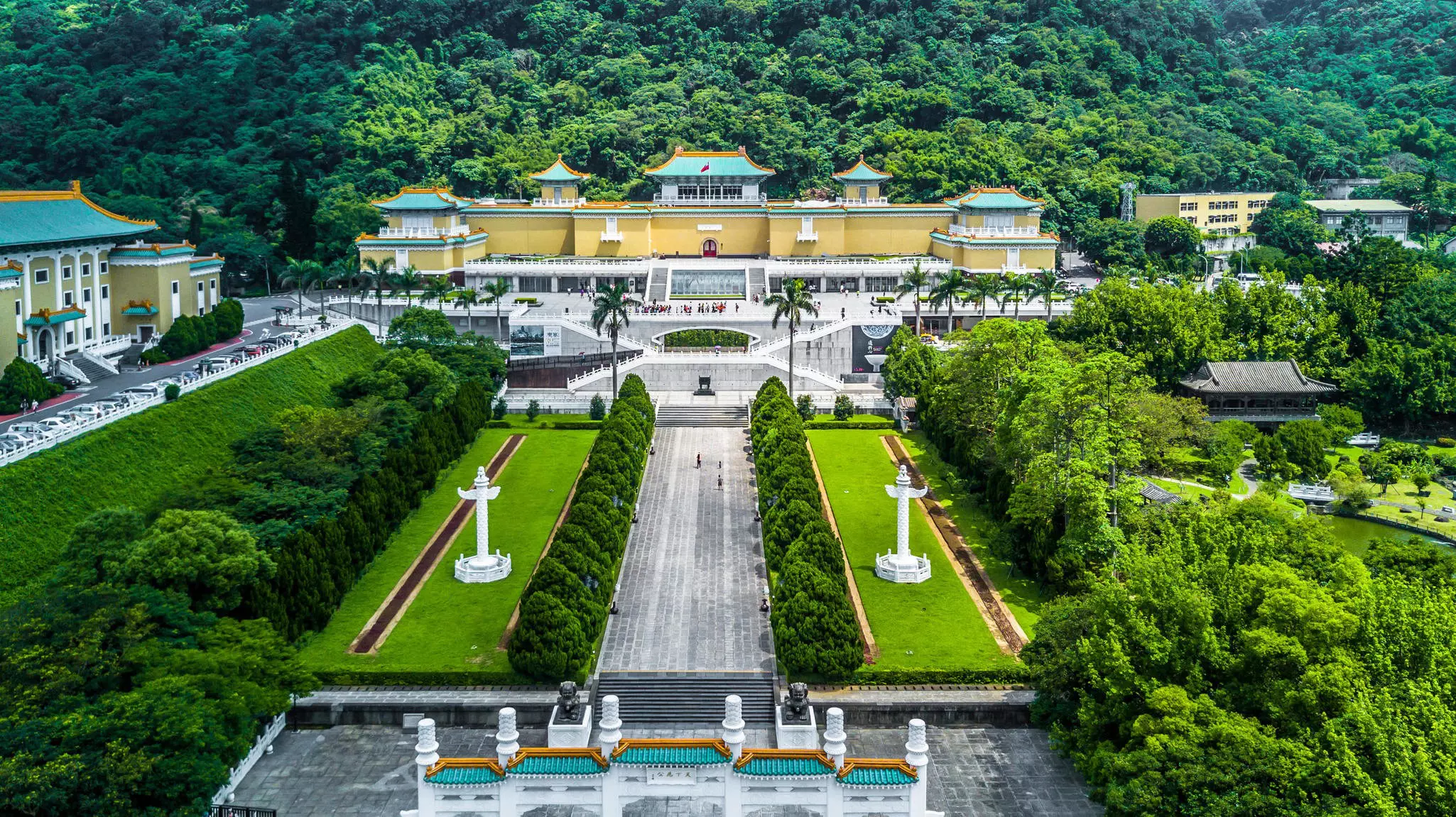 Ornate gardens leading to a vast palace building that houses a museum