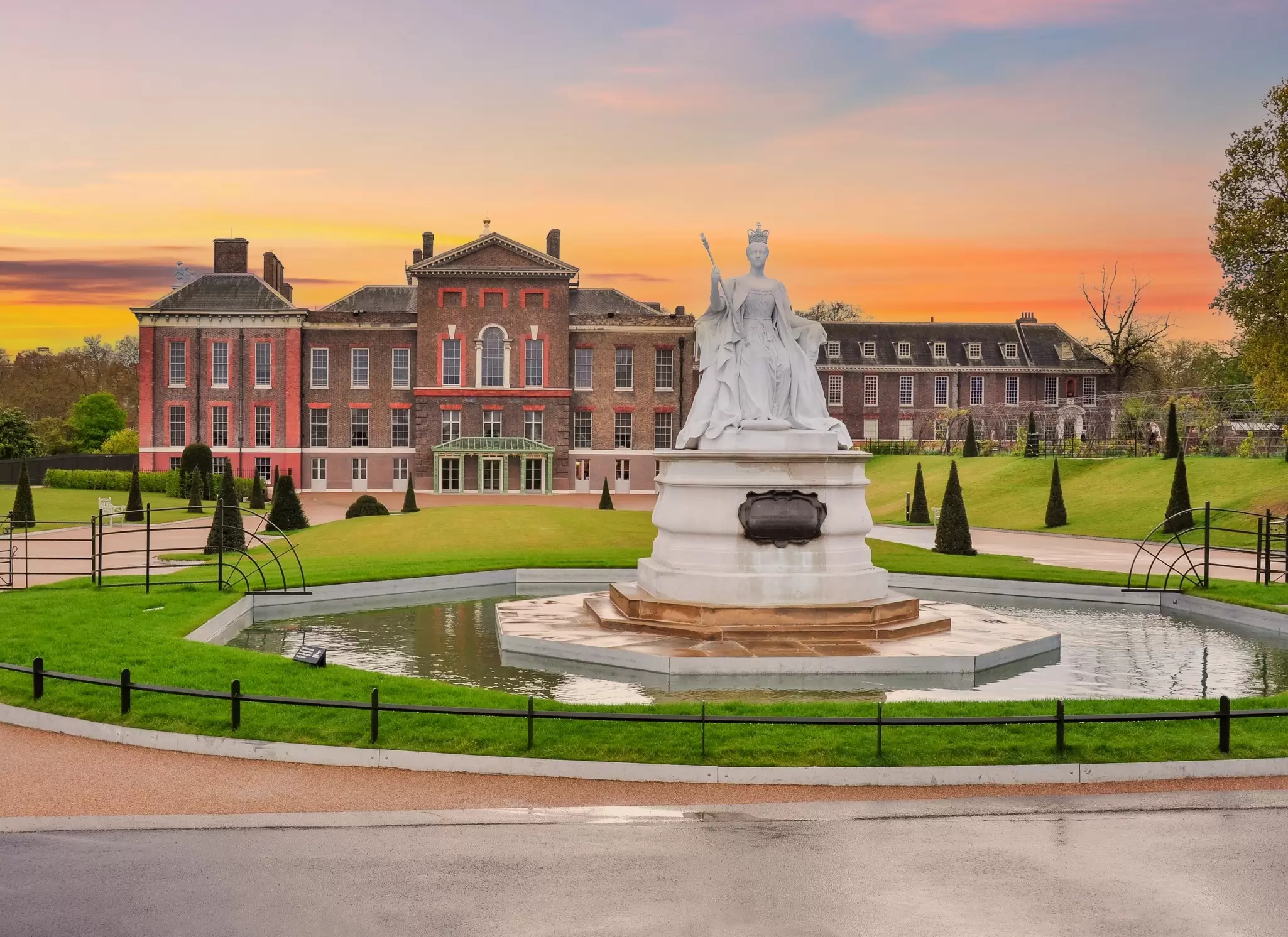 View of Kensington Palace and the Monument to Queen Victoria at sunset in London, UK.