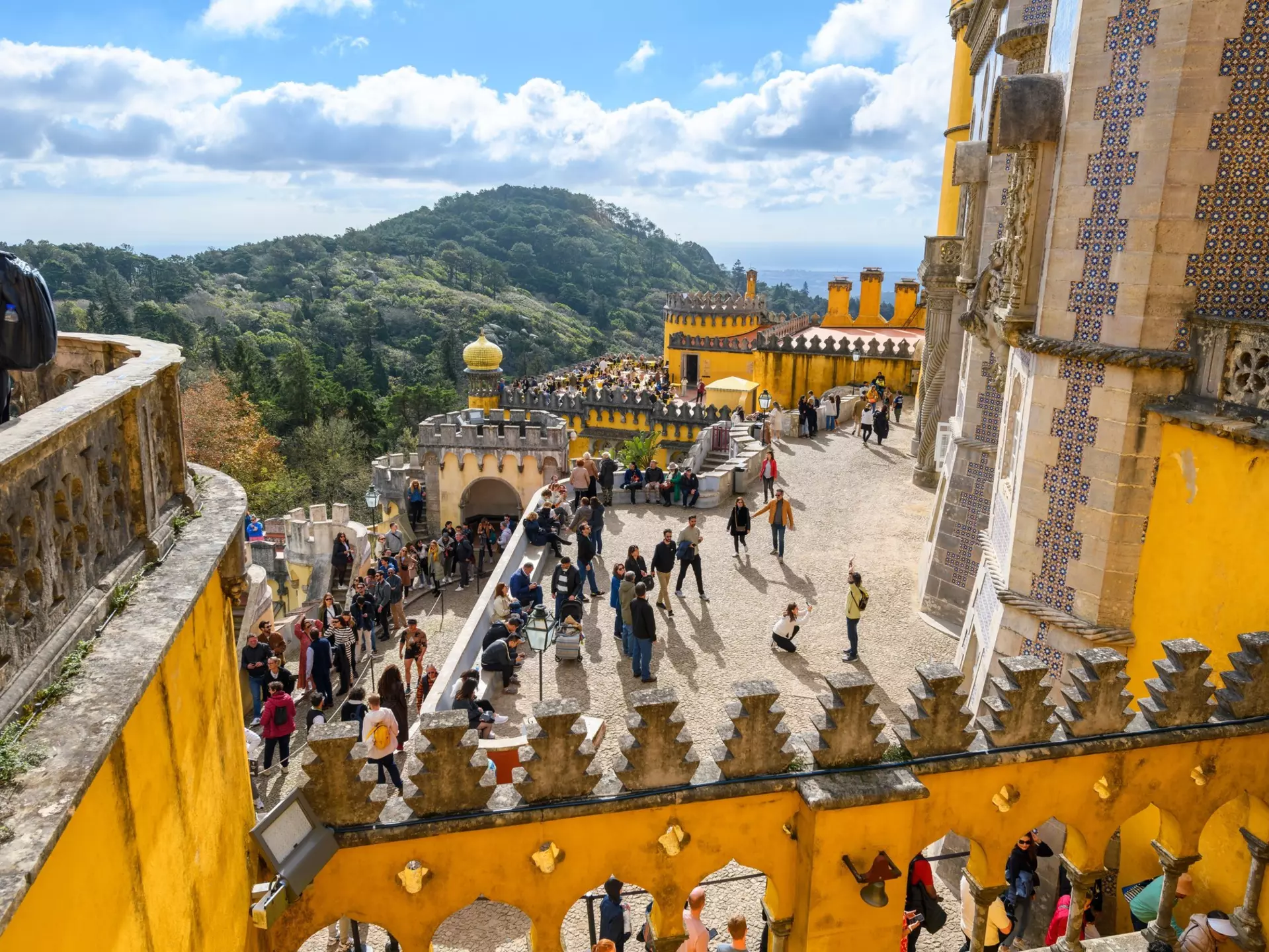 Sintra, Portugal - November 17 2023: Tourists crowd the colorful levels and platforms at the National Palace of Pena, a Romanticist castle in São Pedro de Penaferrim, in the mountains of Sintra.
