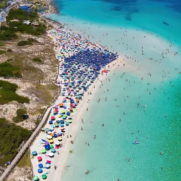Aerial view of the crowded paradise beach La Pelosa in Stintino, Sardinia