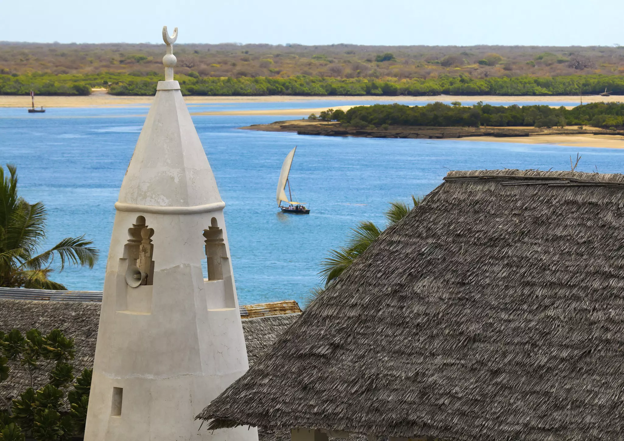 Dhow sailing between Lamu and Manda islands with the minaret of Friday Mosque in foreground © Eric Lafforgue / Lonely Planet