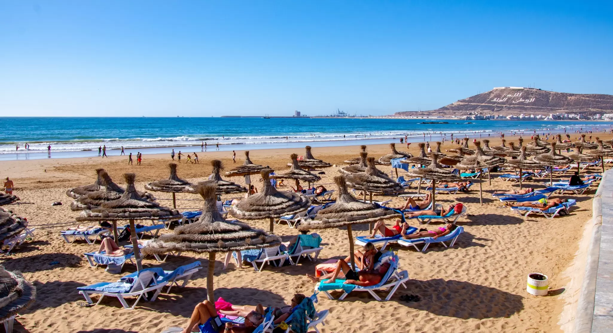 Sunseekers enjoying the city beach at Agadir. Gilles Rivest/Shutterstock