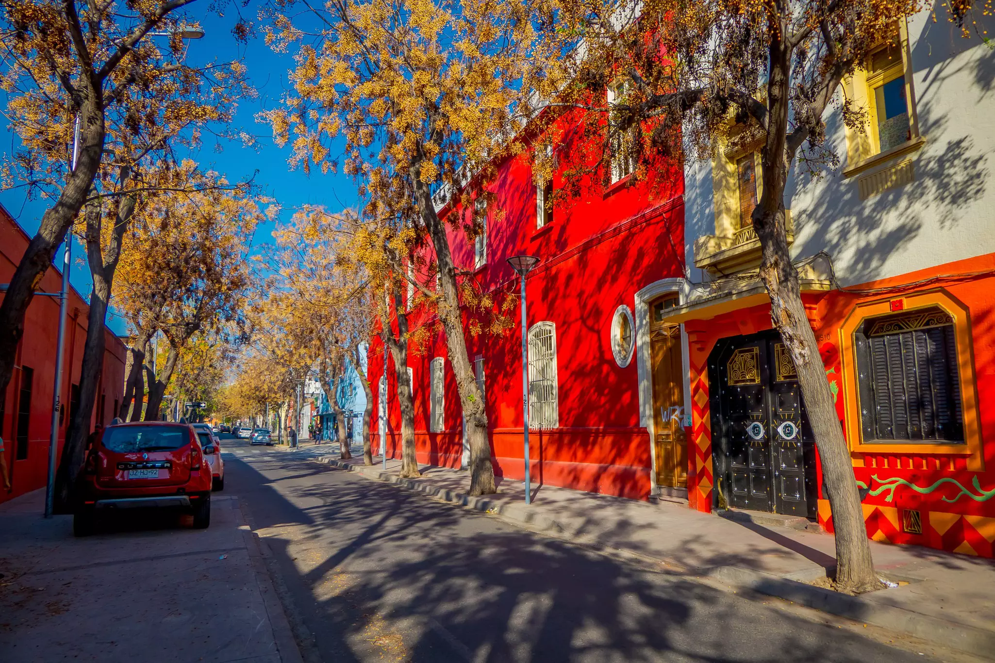 Brightly painted houses along a quiet street in a city neighborhood.