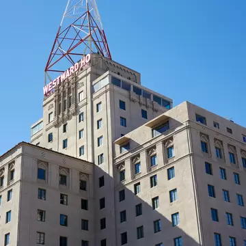 Ornate beige Westward Ho tower with its red rooftop sign and lattice mast in downtown Phoenix