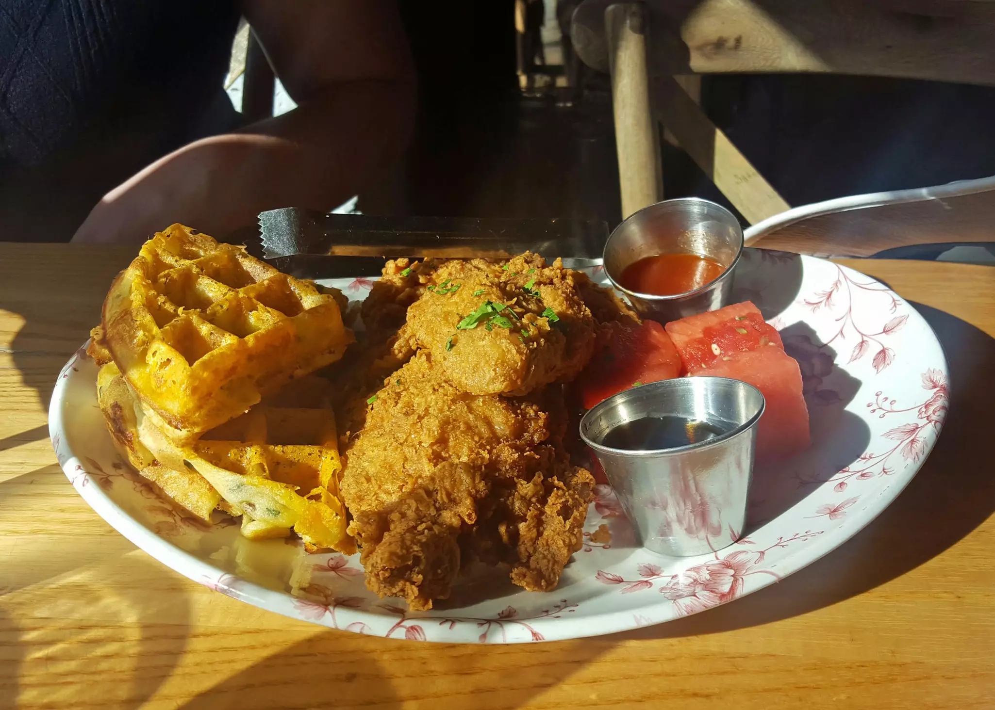 Sunday morning brunch of fried chicken, waffles, and marinated watermelon with bourbon maple syrup and hot sauce at Yardbird Southern Table and Bar in Miami Beach, Florida.