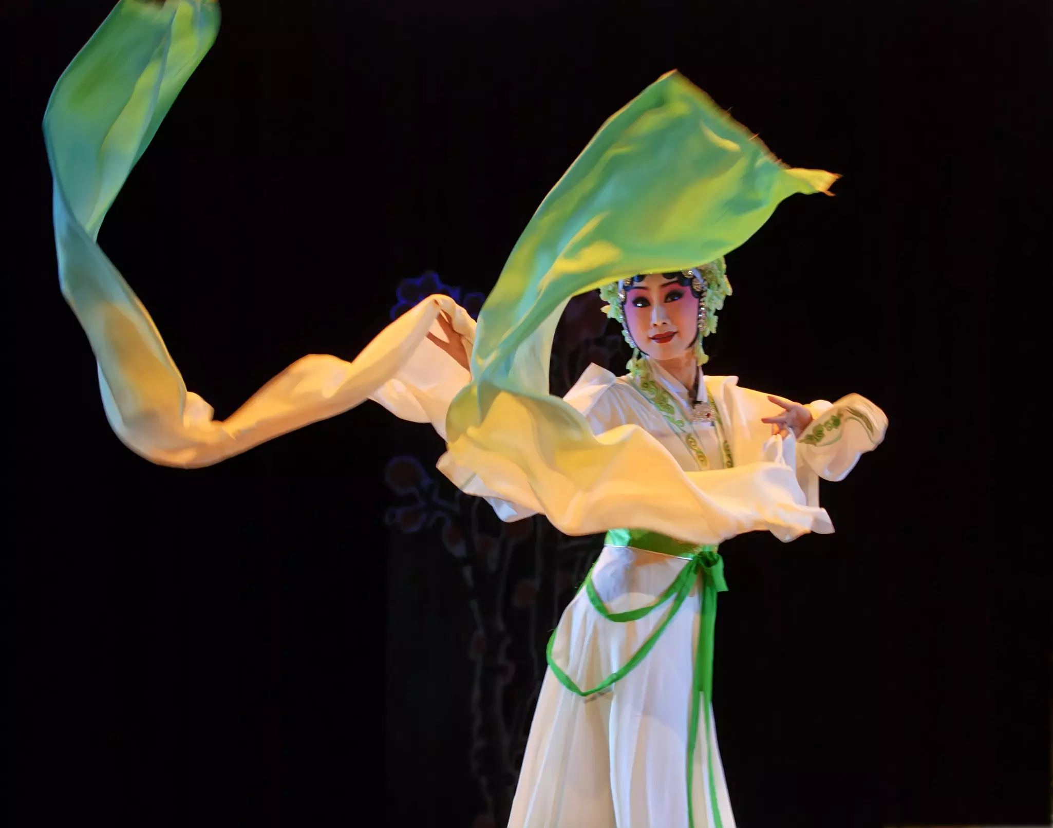 A man sits at a desk with a laptop. Behind him is a stunning view of olive groves. A painting by artist Georgia O'Keeffe is propped against the wall