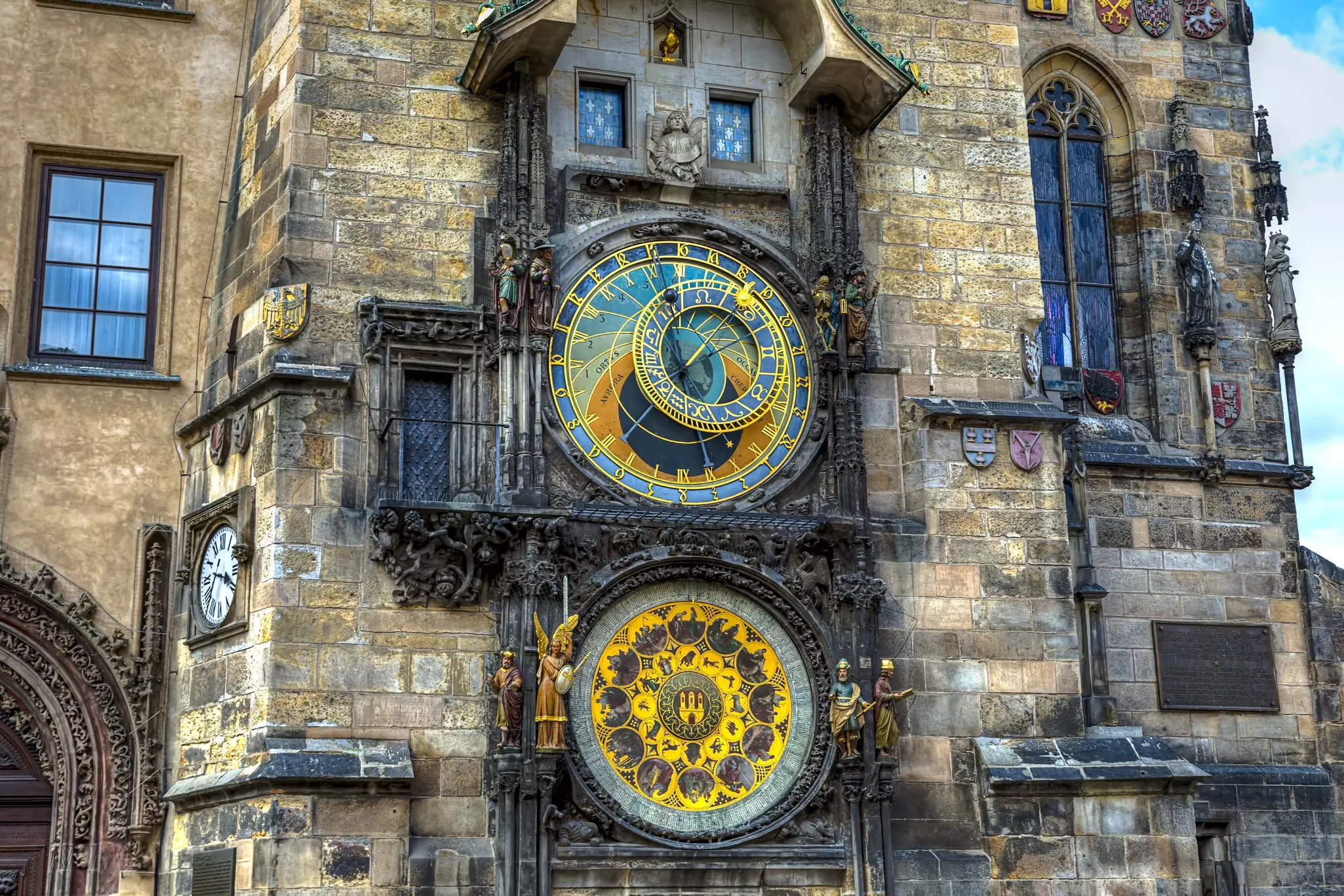 An elaborate clock with two faces on the side of a historic building.