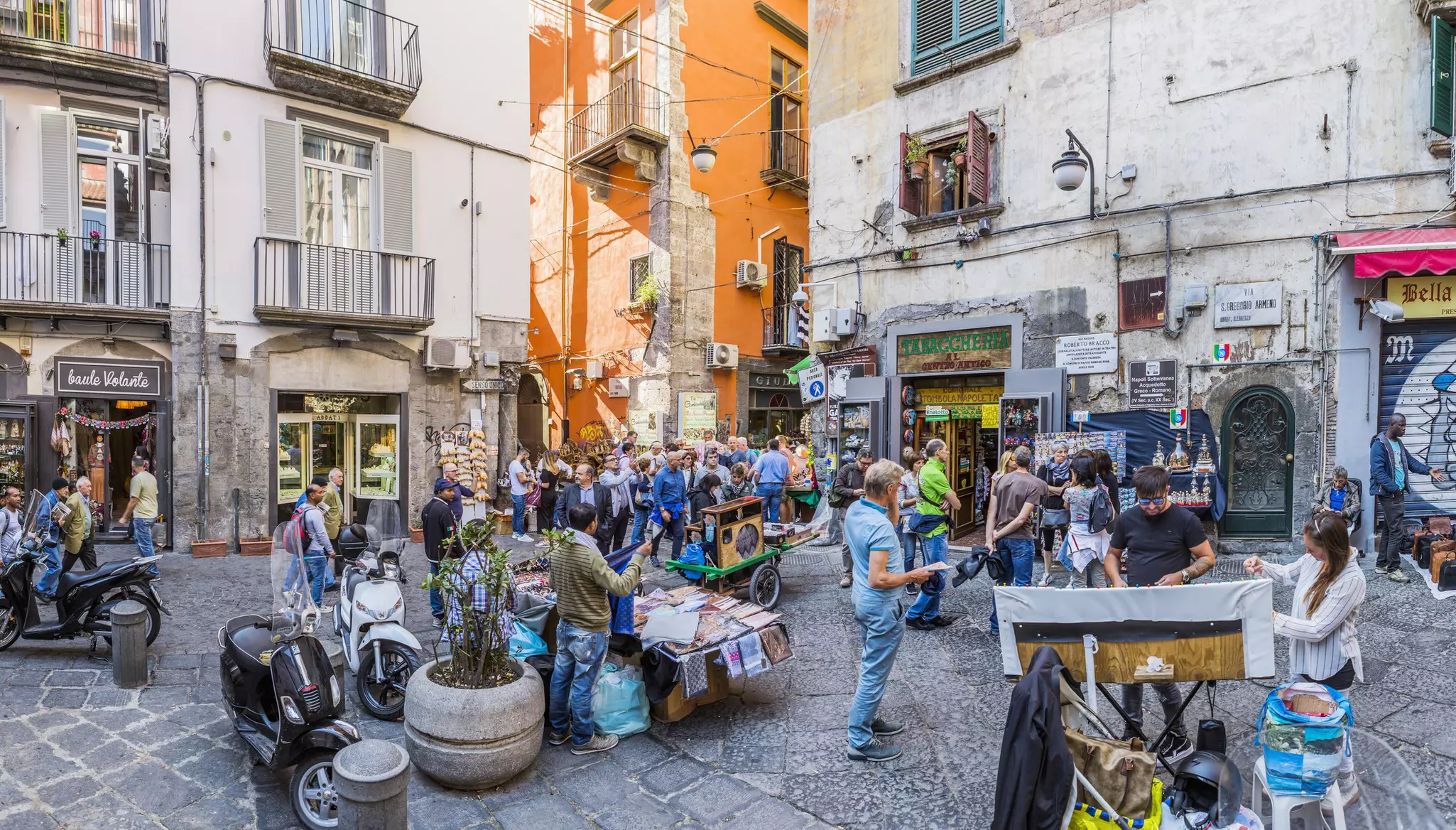 A busy street scene with people moving down narrow lanes