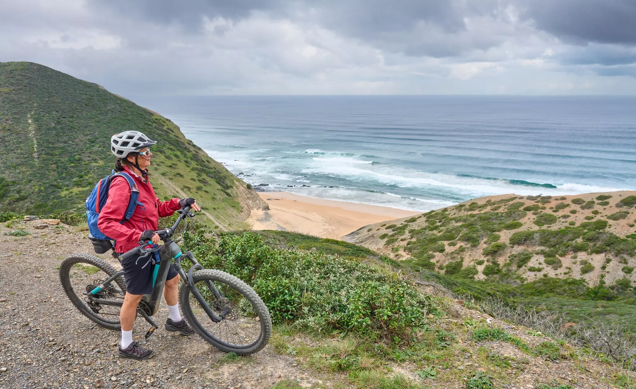 A cyclist on the rocky cliffs of the Vicentina Coast.