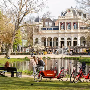 A cargo bike beside the Hamer pavilion among trees in Vondelpark