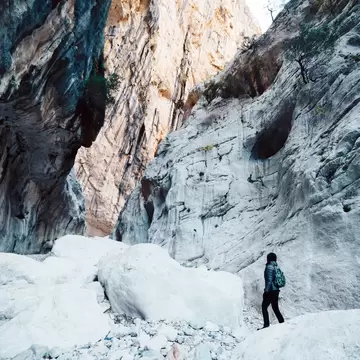 Woman hiking inside the deepest canyon in Europe - Activity and Health concept - Gola Su Gorroppu.