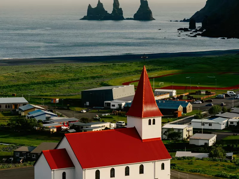 A town by the sea with a red-roofed church.