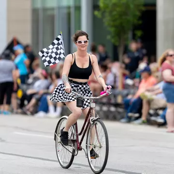 A woman rides a bike down Pennsylvania Street prior to the Indy 500 Parade, Indianapolis, Indiana, Midwest, USA