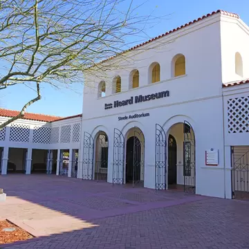 White Spanish Colonial facade and brick courtyard of the Heard Museum in Phoenix, Arizona