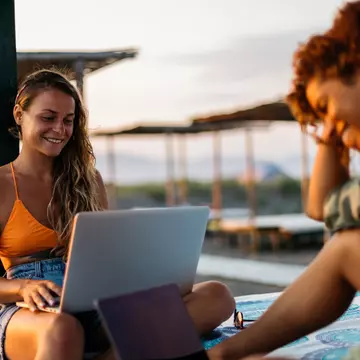 Girls on beach on laptops.jpg