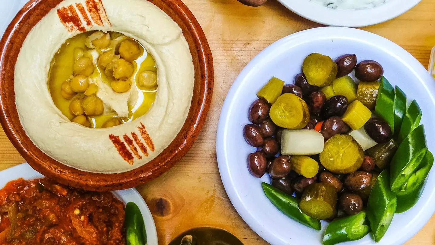 View of hummus and various appetisers served on a wooden table