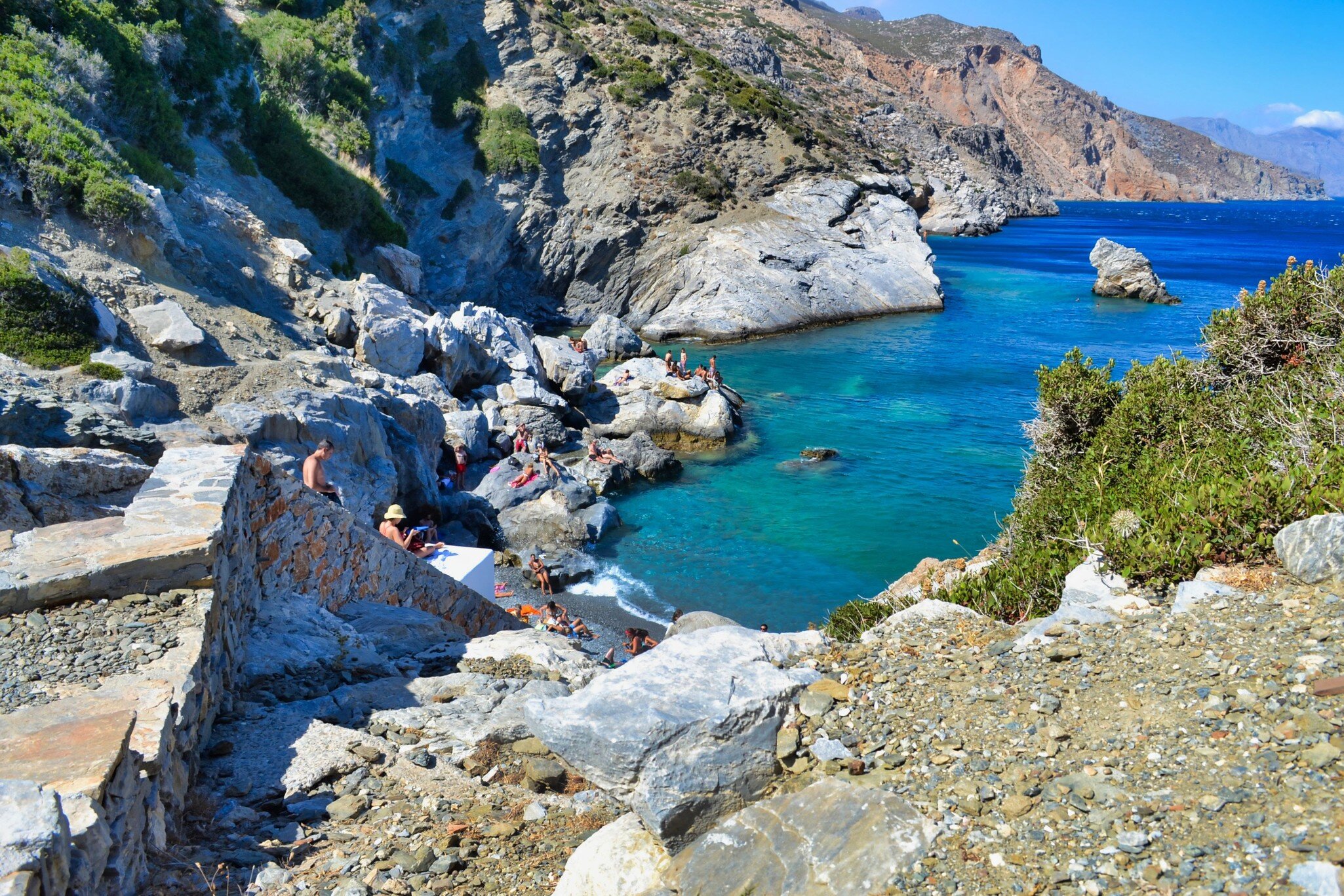People sunbathing on the rocks in Agia Anna beach at Amorgos island of Greece.; Shutterstock ID 2027401883; your: Barbara Di Castro; gl: 65050; netsuite: digital; full: poi