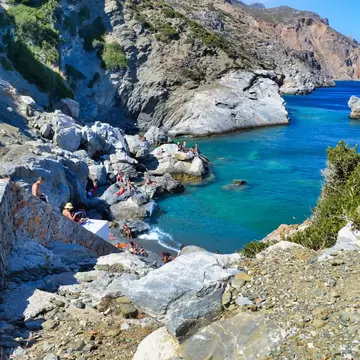 People sunbathing on the rocks in Agia Anna beach at Amorgos island of Greece.; Shutterstock ID 2027401883; your: Barbara Di Castro; gl: 65050; netsuite: digital; full: poi