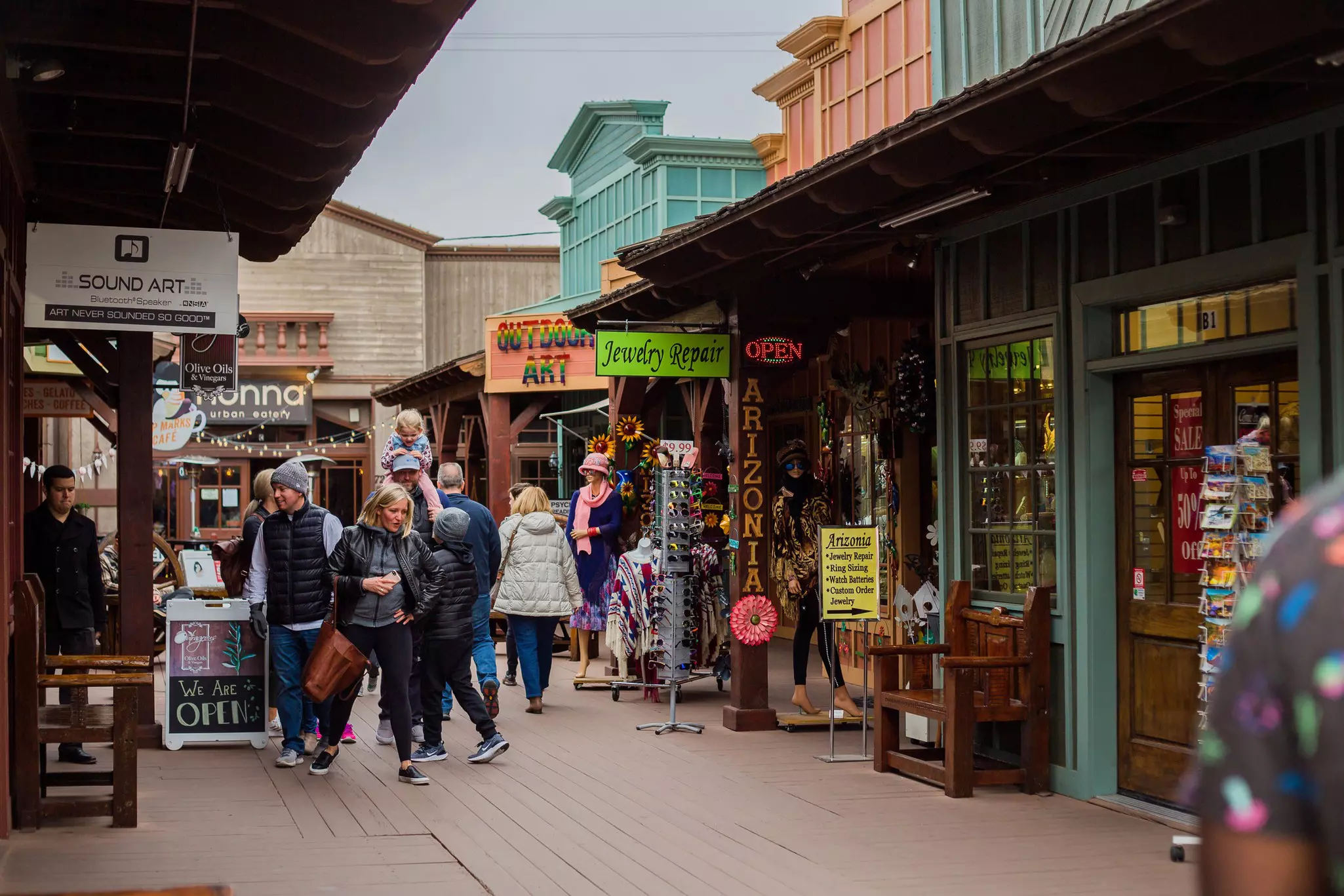 Pedestrians walk through a bustling Old Town Scottsdale street known for its souvenir shops