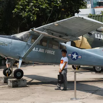 A US Air Force propeller aircraft on outdoor display, visitors walking past.