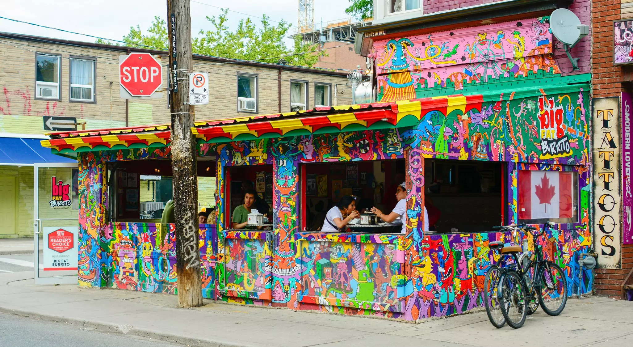Bicycles parked beside big fat burrito outlet in Kensington Market, Toronto