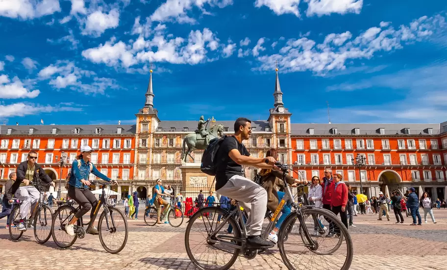 Spain, Madrid..A view of  La Plaza Mayor square in Madrid where there were a group of tourists riding bicycles. The Plaza Mayor square is one of the most famous squares in the town and located in the city center. People walk and cycle through the streets.The Plaza Mayor (Main Square) was built during Philip III's reign (1598–1621).