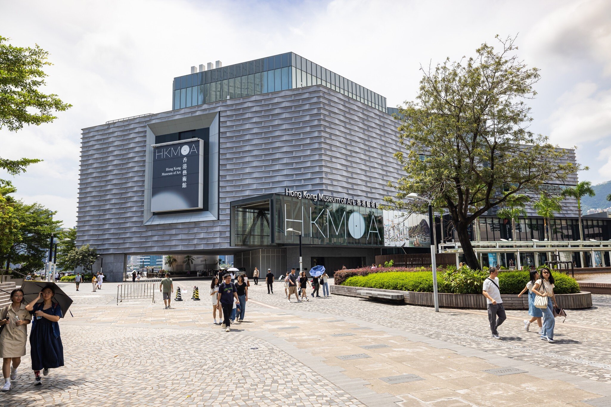 Hong Kong - September 02, 2024: The Hong Kong Museum of Art (HKMoA) stands as a modern cultural landmark. Visitors stroll outside the sleek architectural building, enjoying a sunny day in the city, License Type: media, Download Time: 2026-08-24T18:06:36.000Z, User: LP_NZhan, Editorial: true, purchase_order: 65050 - Digital Destinations and Articles, job: App Content, client: Lonely Planet App, other: Nadine Zhan 