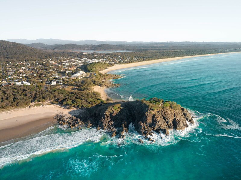Sunrise aerial of Cabarita Headland in New South Wales, Australia. Beautiful sunrise light with waves on white sand beach. One of many favourite backpacker stop on road trip holiday.