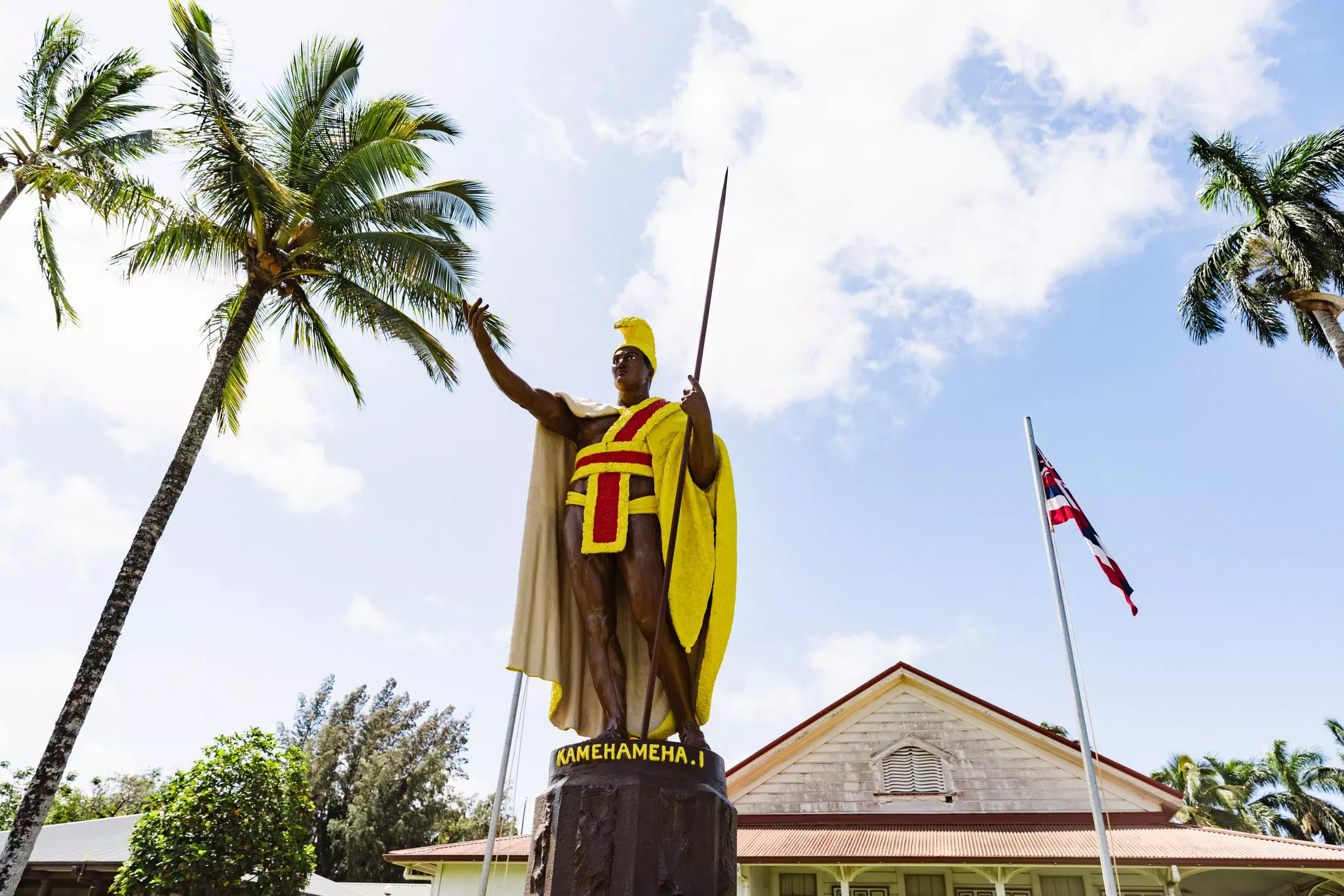A statue of a figure with a yellow and red cloak.
