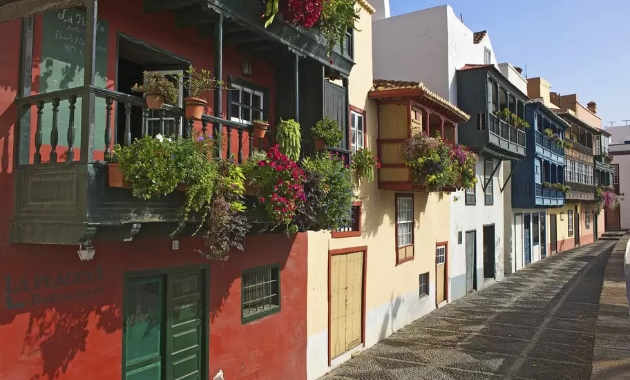 Colourful houses with flower-filled wooden balconies on a cobbled street in Santa Cruz de la Palma, Canary Islands