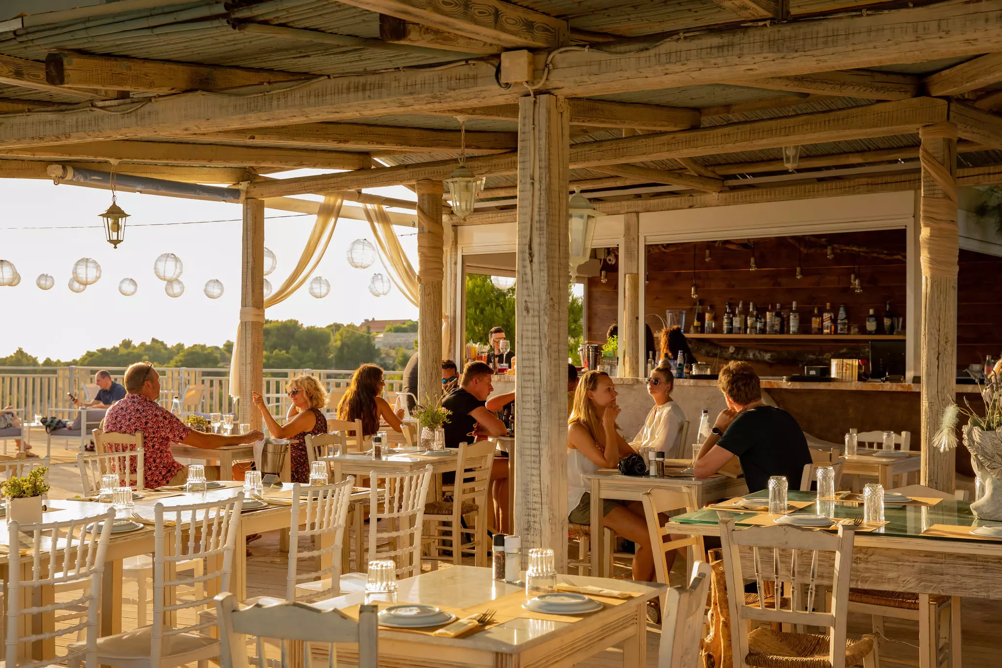 Tourists dining on a terrace at a restaurant in Zakynthos. LauraVl/Shutterstock