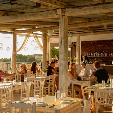 A restaurant terrace with diners at sunset.