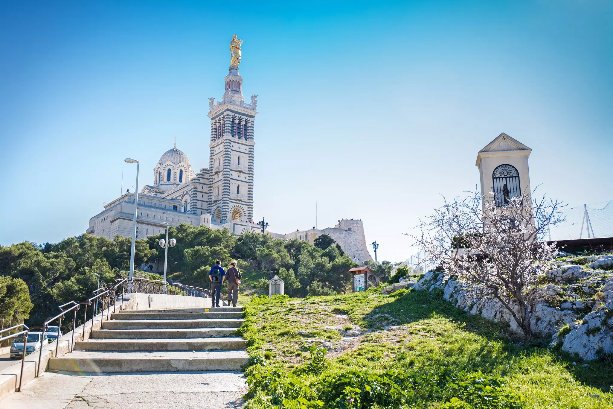 A view of a neo-Romasque church atop a hill under a blue sky