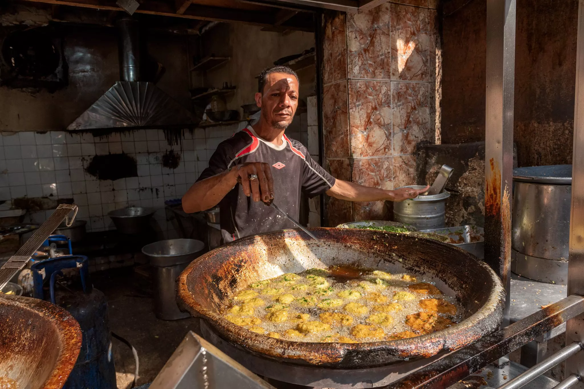 An Egyptian man frying ta’amiyya (fava bean fritters) in Cairo, Egypt.