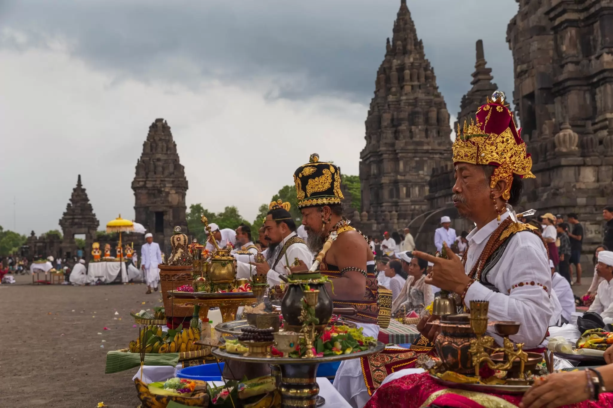 Priests in elaborate head gear perform rituals in front of offerings at a the Prambanan Temple Complex, near Yogakarta, Java, Indonesia