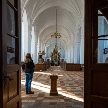 Maribo, Denmark. A woman stands in the entrance to the  Maribo Cathedral.
