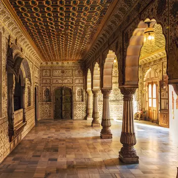 Junagarh Fort view of the Private Audience Hall in Anup Mahal with intricate gold artwork and columned structure. 