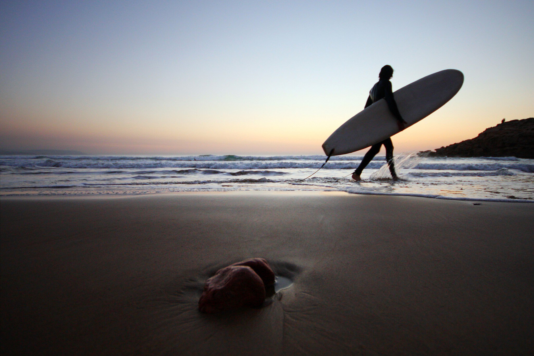 Surfer with surboard at sunset