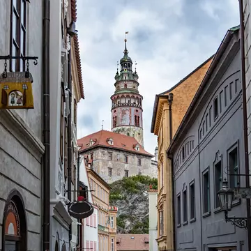 Cesky Krumlov, Czech Republic. View of the Tower of the Krumlov castle from narrow street in the city center. 