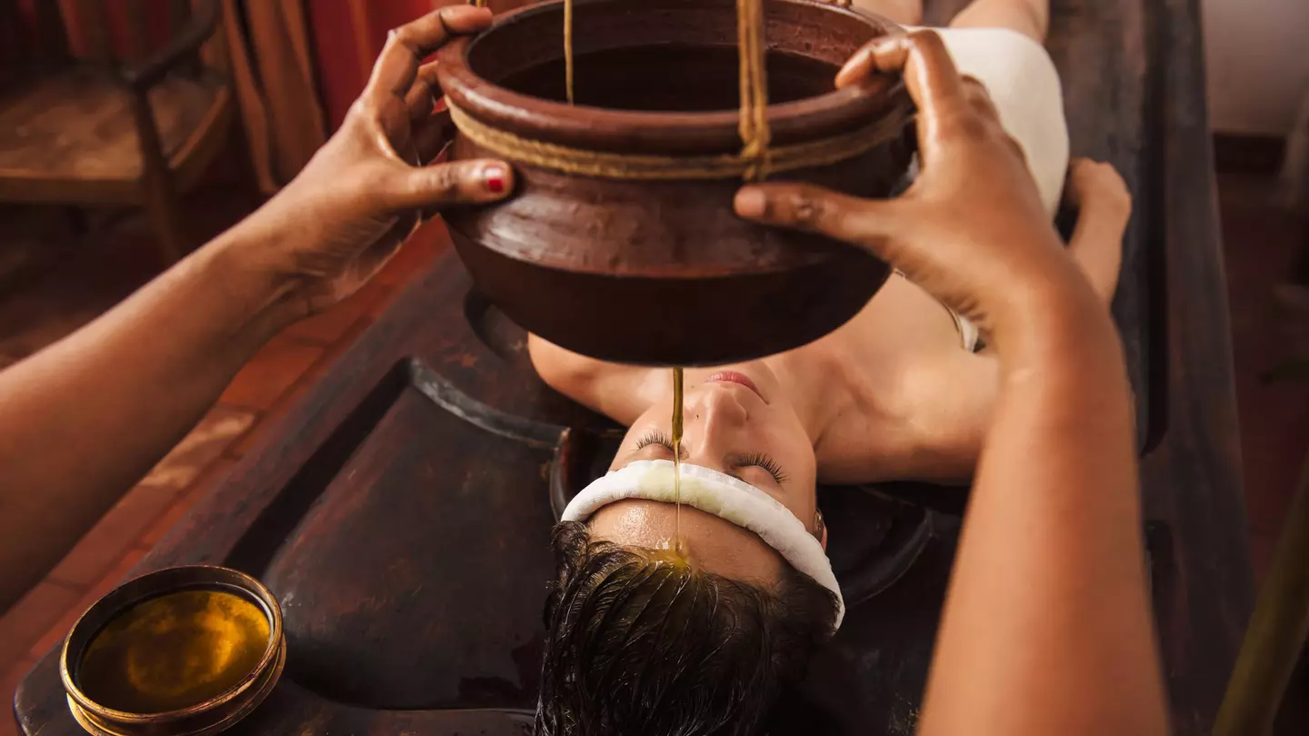 Caucasian woman having Ayurveda shirodhara treatment in India ©Dmytro Gilitukha/Shutterstock