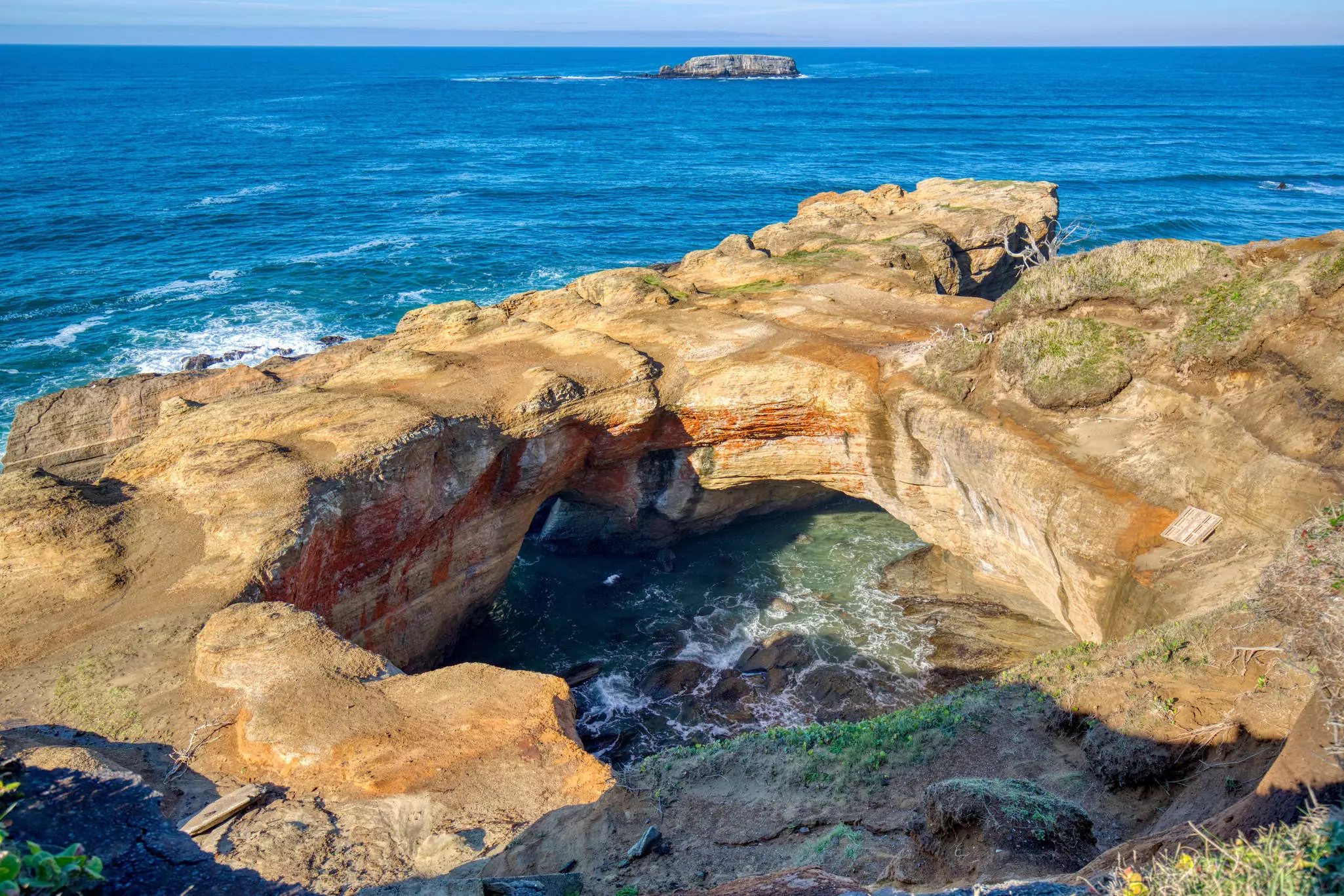 A coastal rock formation where the center has collapsed allowing the sea to rush in.
