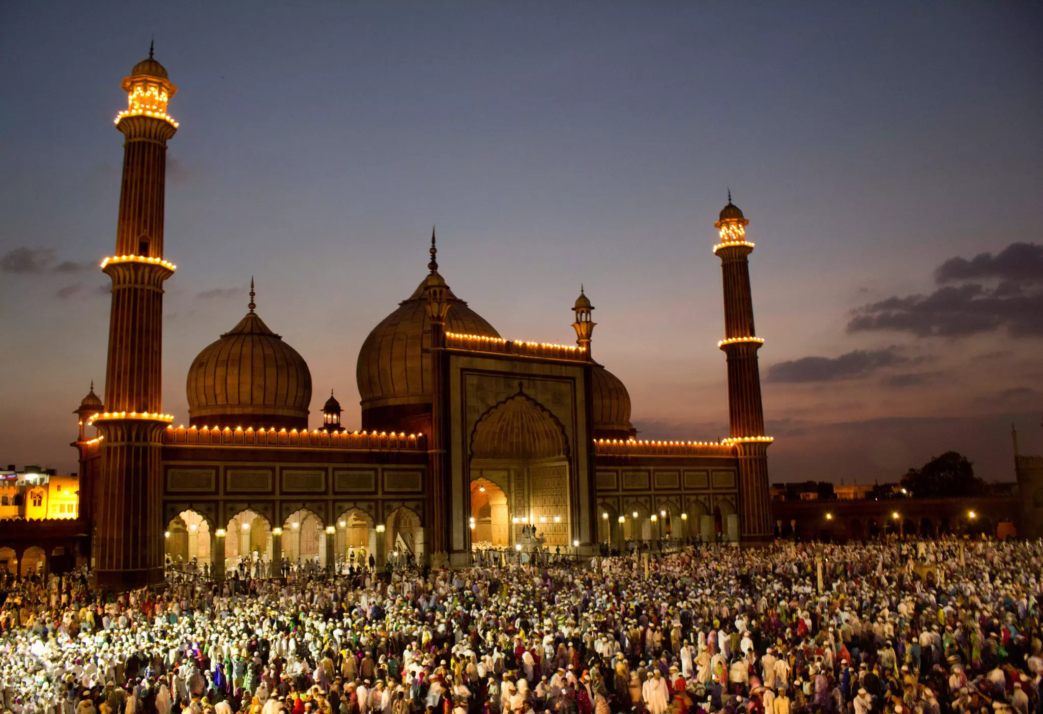Crowds of worshippers in front of the Jama Masjid in Delhi at sunset, India.