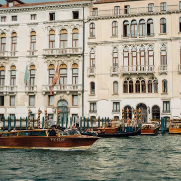 A water taxi cruises along the canal in Venice. Cheungjoproduction/Shutterstock
