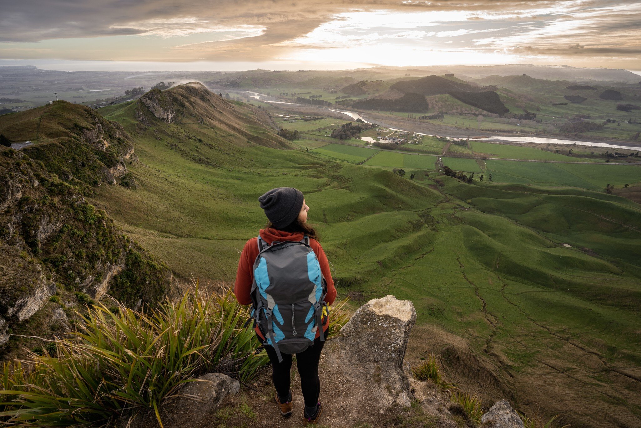 Woman backpacker standing at the top of Te Mata Peak in Hawke's Bay, New Zealand. Traveler concept
