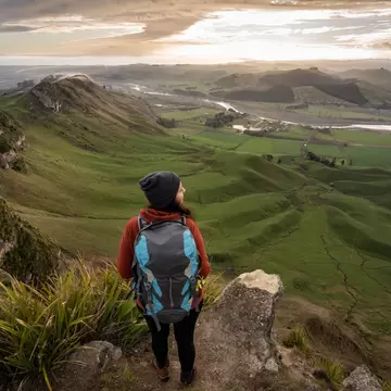 Woman backpacker standing at the top of Te Mata Peak in Hawke's Bay, New Zealand. Traveler concept