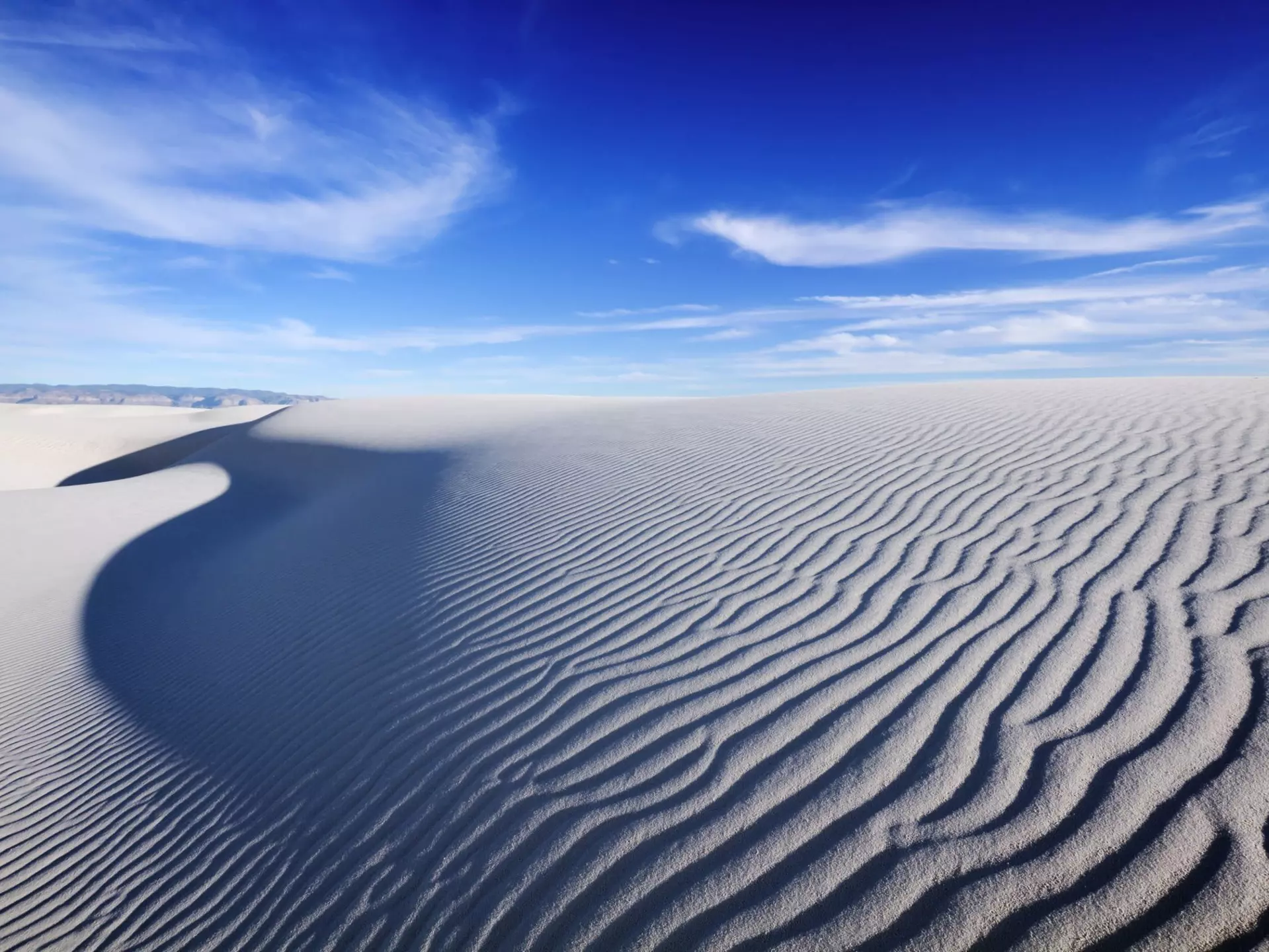 Tranquil image of sand dunes and beautiful blue sky, White Sands National Monument. sumikophoto / Shutterstock
