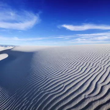 Tranquil image of sand dunes and beautiful blue sky, White Sands National Monument. sumikophoto / Shutterstock