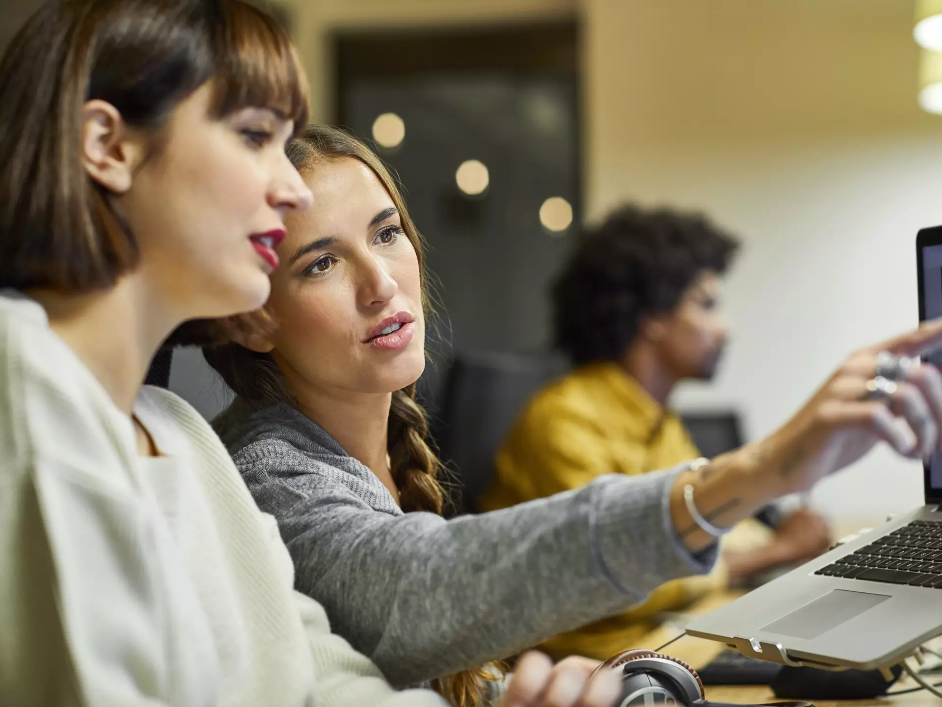 Coworkers discussing over computer in office